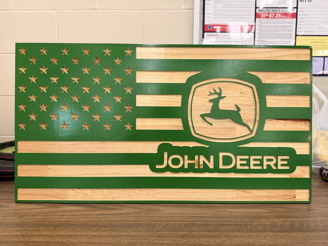 Green-stained carved American flag with a leaping deer in the union